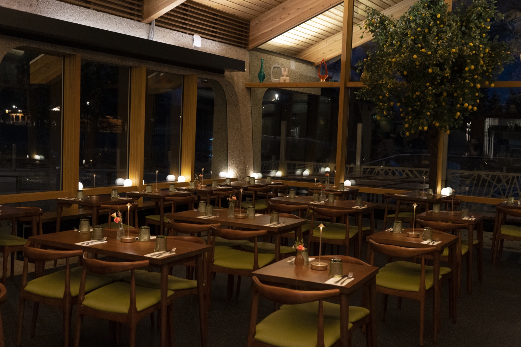 Dining room at night with lemon tree and candlelit tables