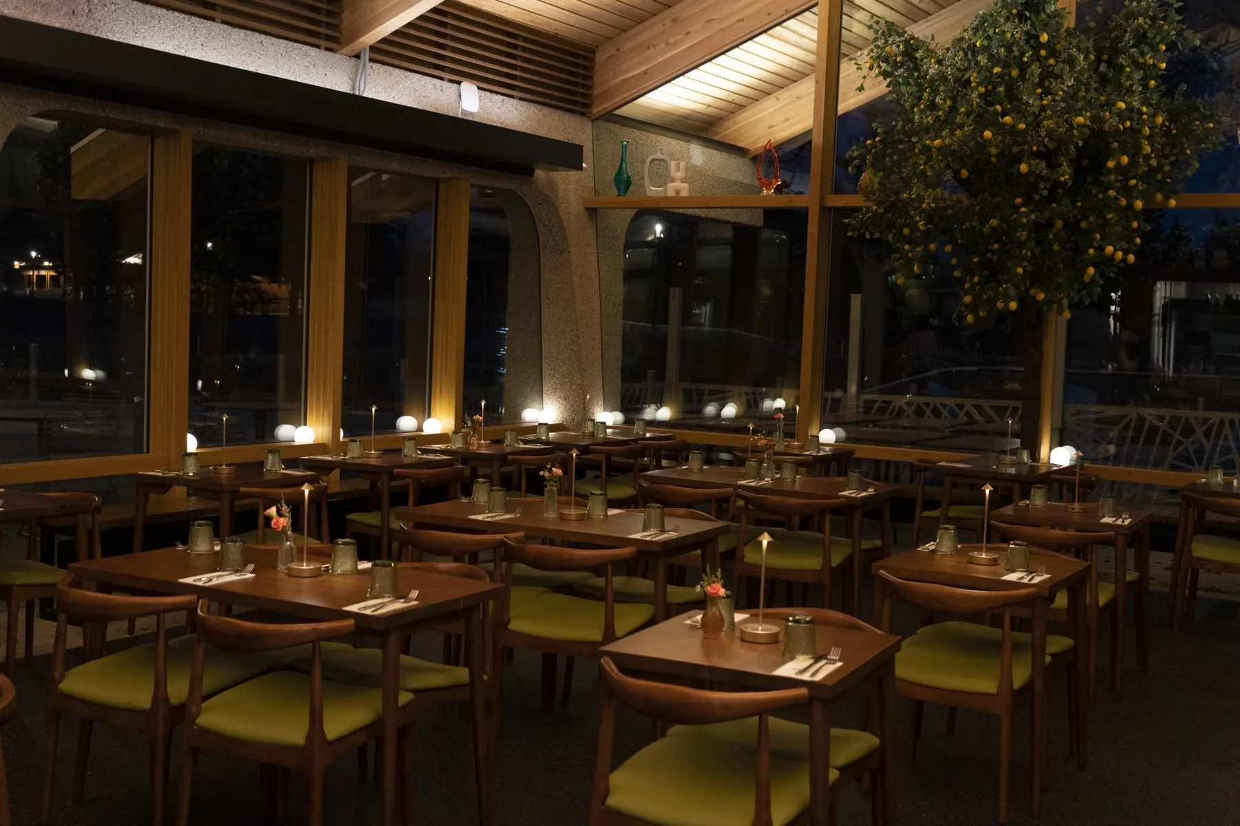 Dining room at night with lemon tree and candlelit tables